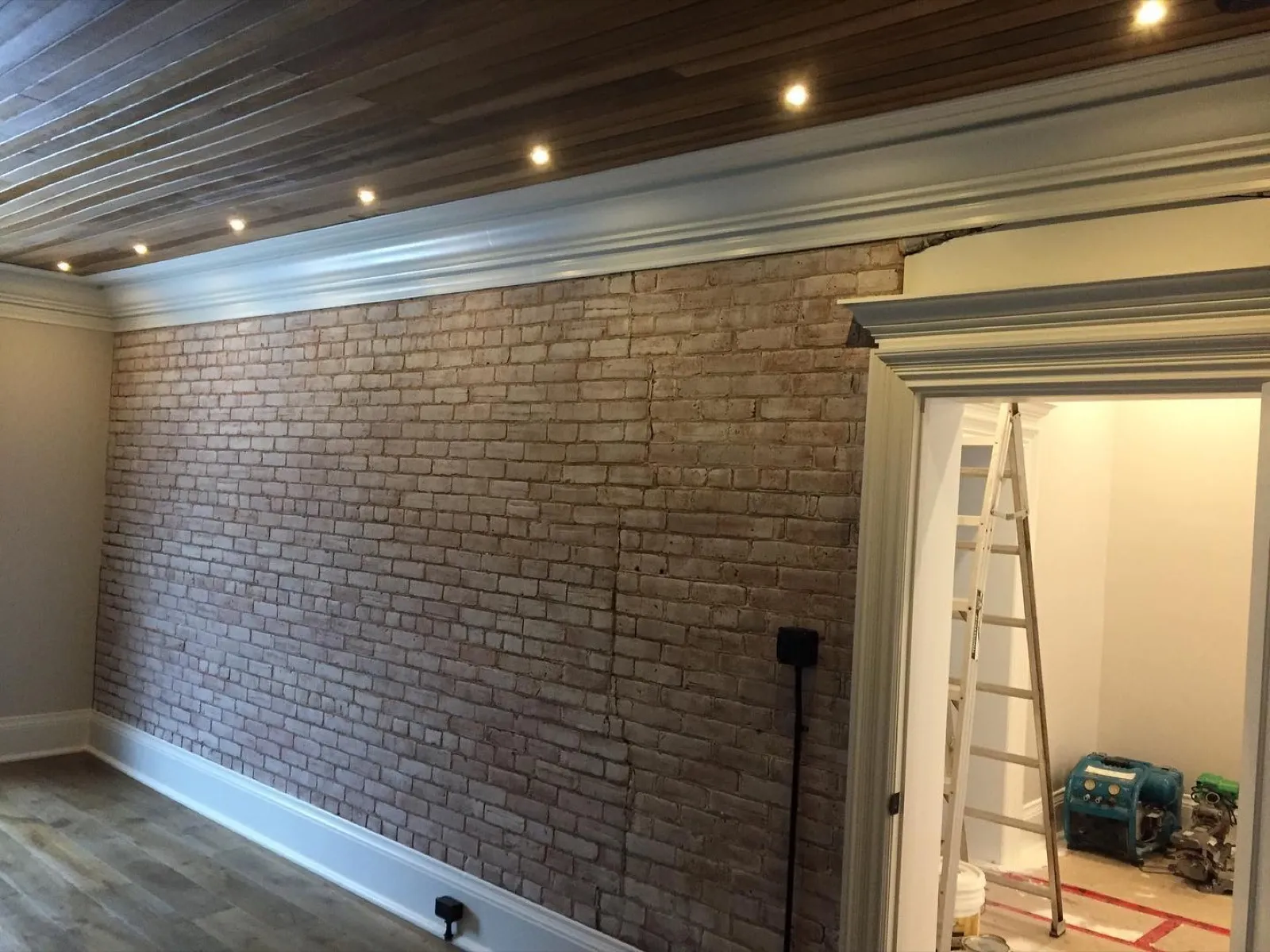 Wood plank ceiling with crown moulding and exposed brick renovation by Walkercraft Carpentry