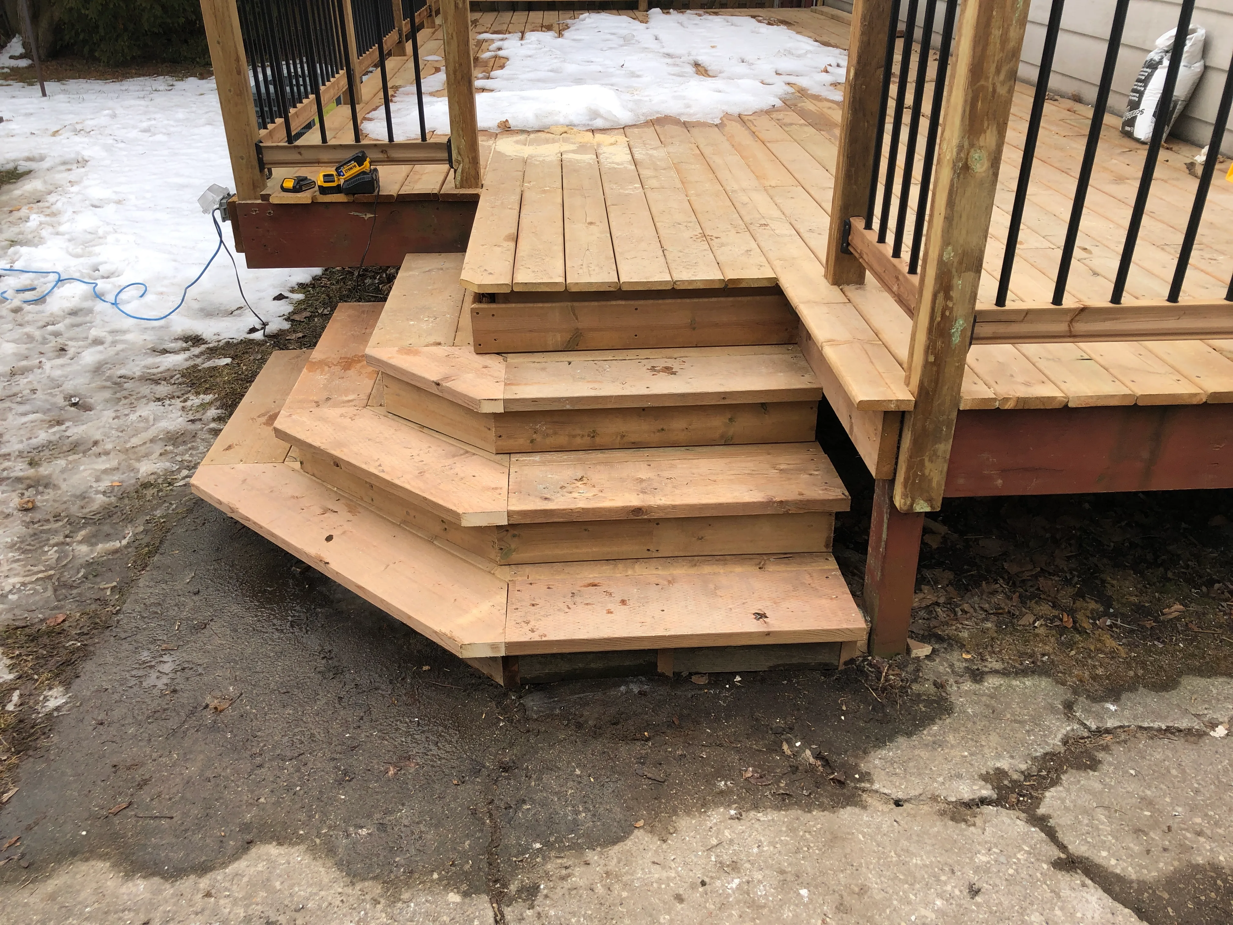Custom corner wrap deck stairs with metal balusters by Walkercraft Carpentry