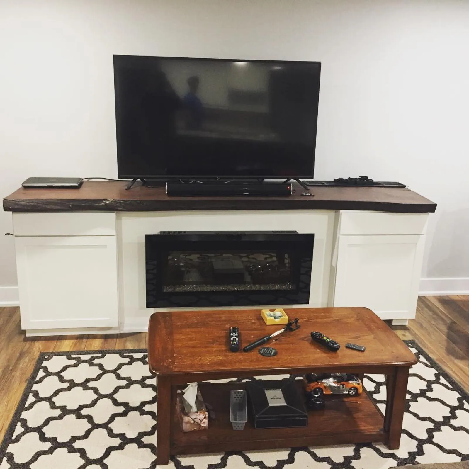 Custom built-in fireplace surround with live-edge wood mantel by Walkercraft Carpentry