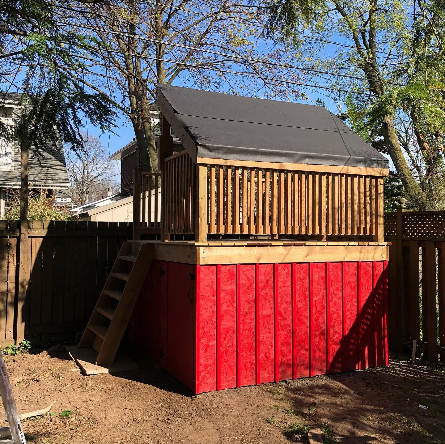 Custom children's playhouse with elevated deck and storage by Walkercraft Carpentry